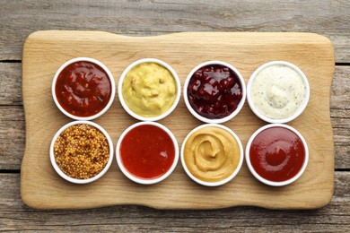 Photo of Different tasty sauces in bowls on wooden table, top view