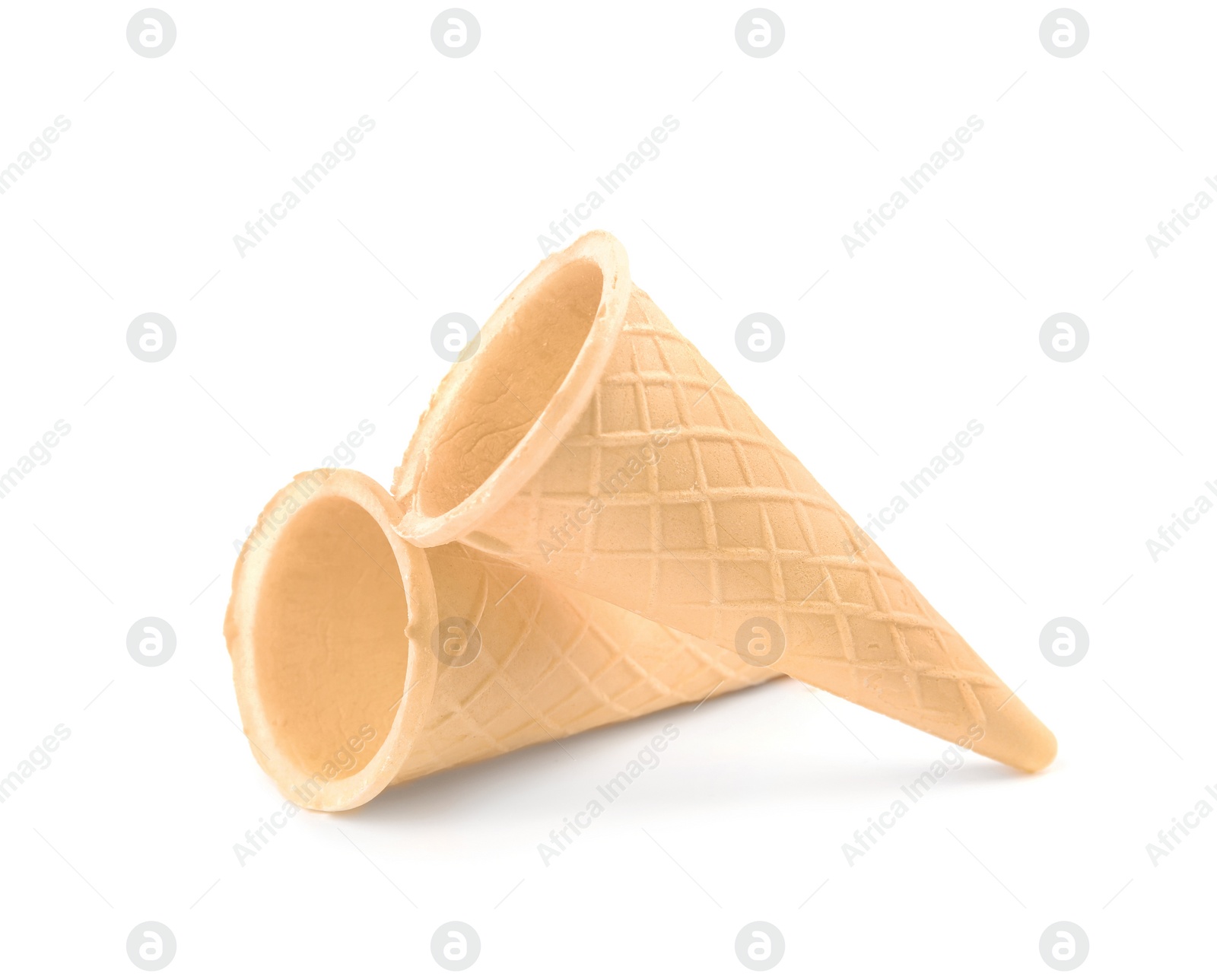 Photo of Empty crispy waffle cones for ice cream on white background