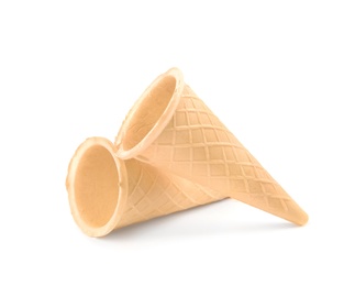 Photo of Empty crispy waffle cones for ice cream on white background