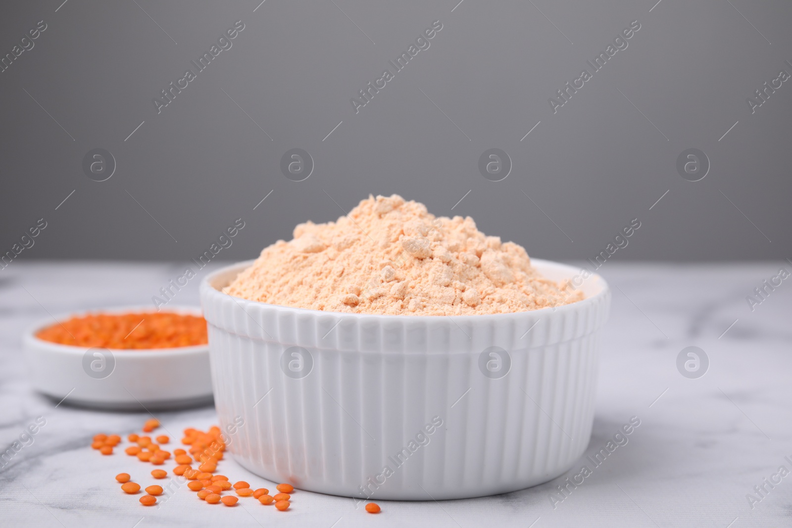 Photo of Lentil flour and seeds on white marble table