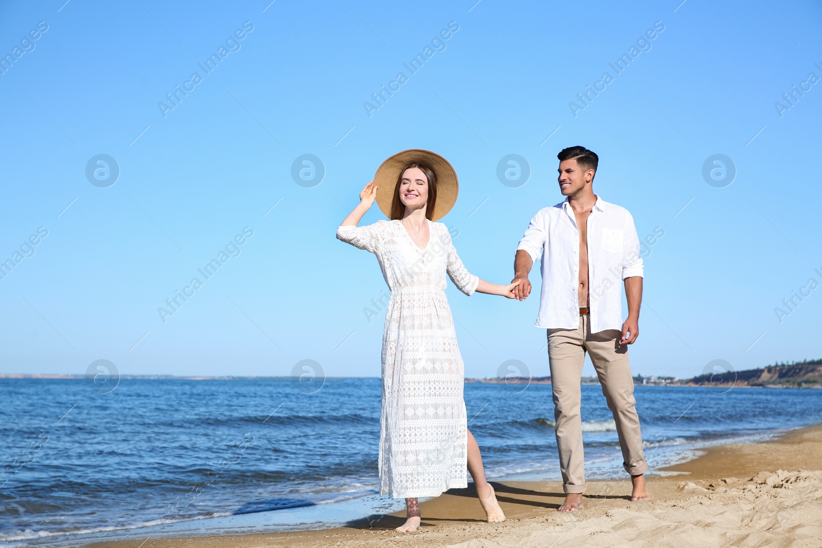 Photo of Lovely couple walking on beach. Space for text