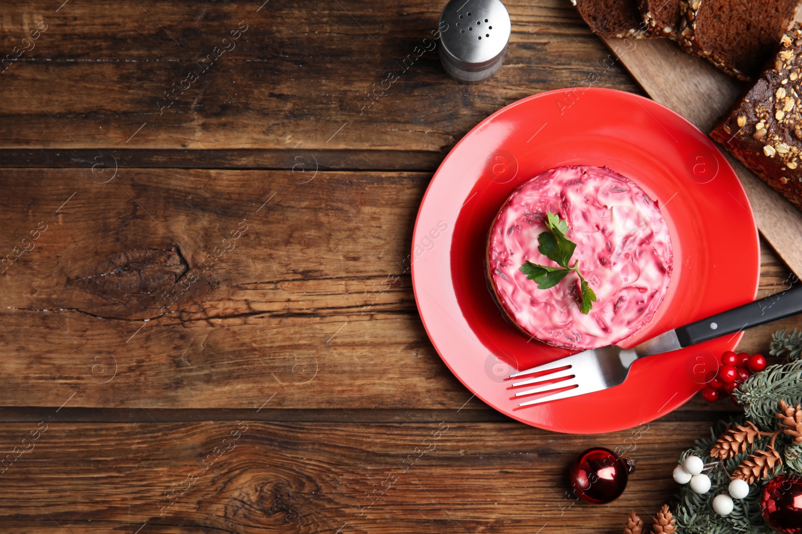 Photo of Herring under fur coat served on wooden table, flat lay with space for text. Traditional russian salad