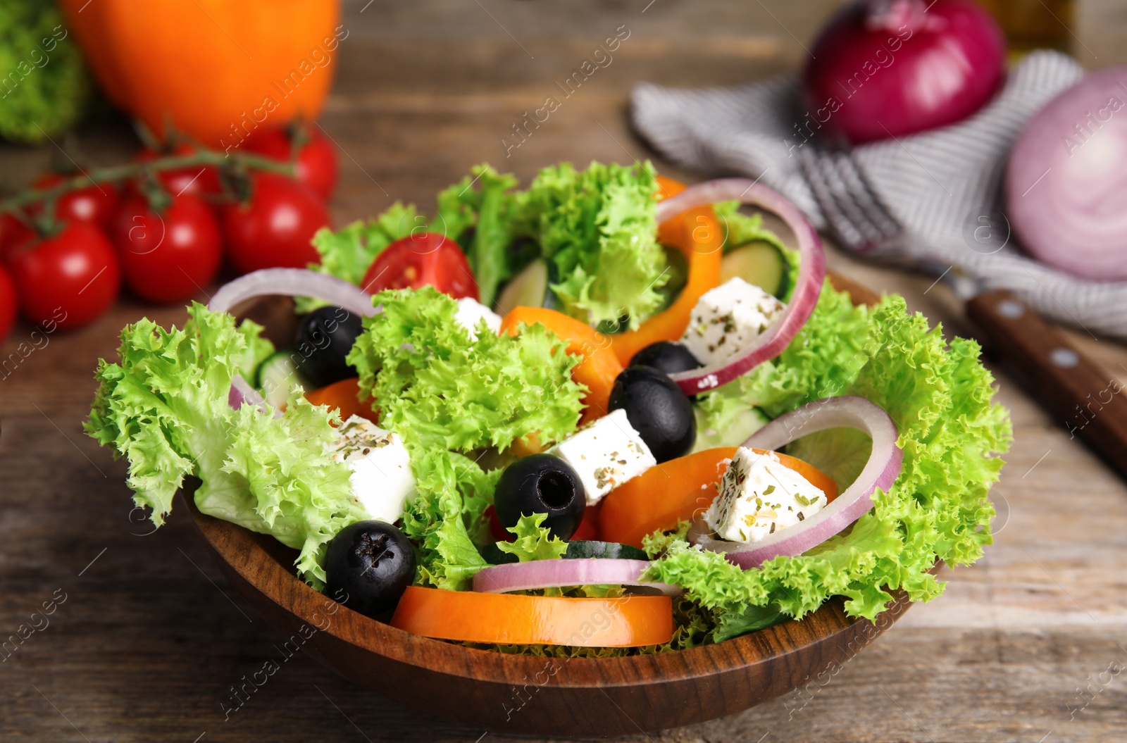 Photo of Tasty fresh Greek salad on wooden table, closeup