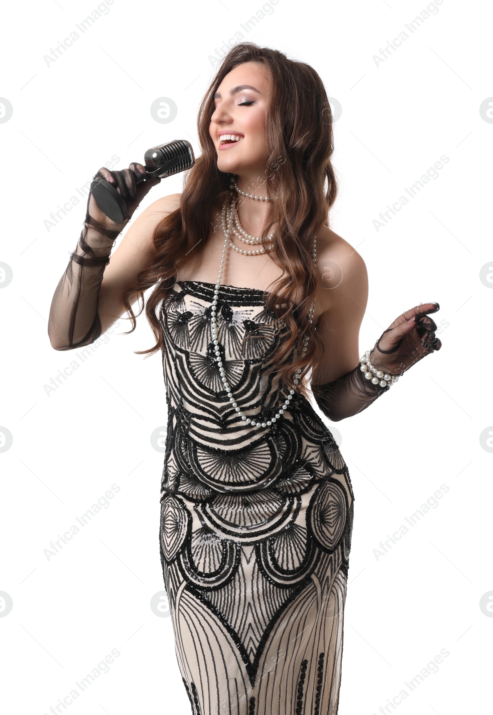 Photo of Beautiful young woman in stylish dress with microphone singing on white background