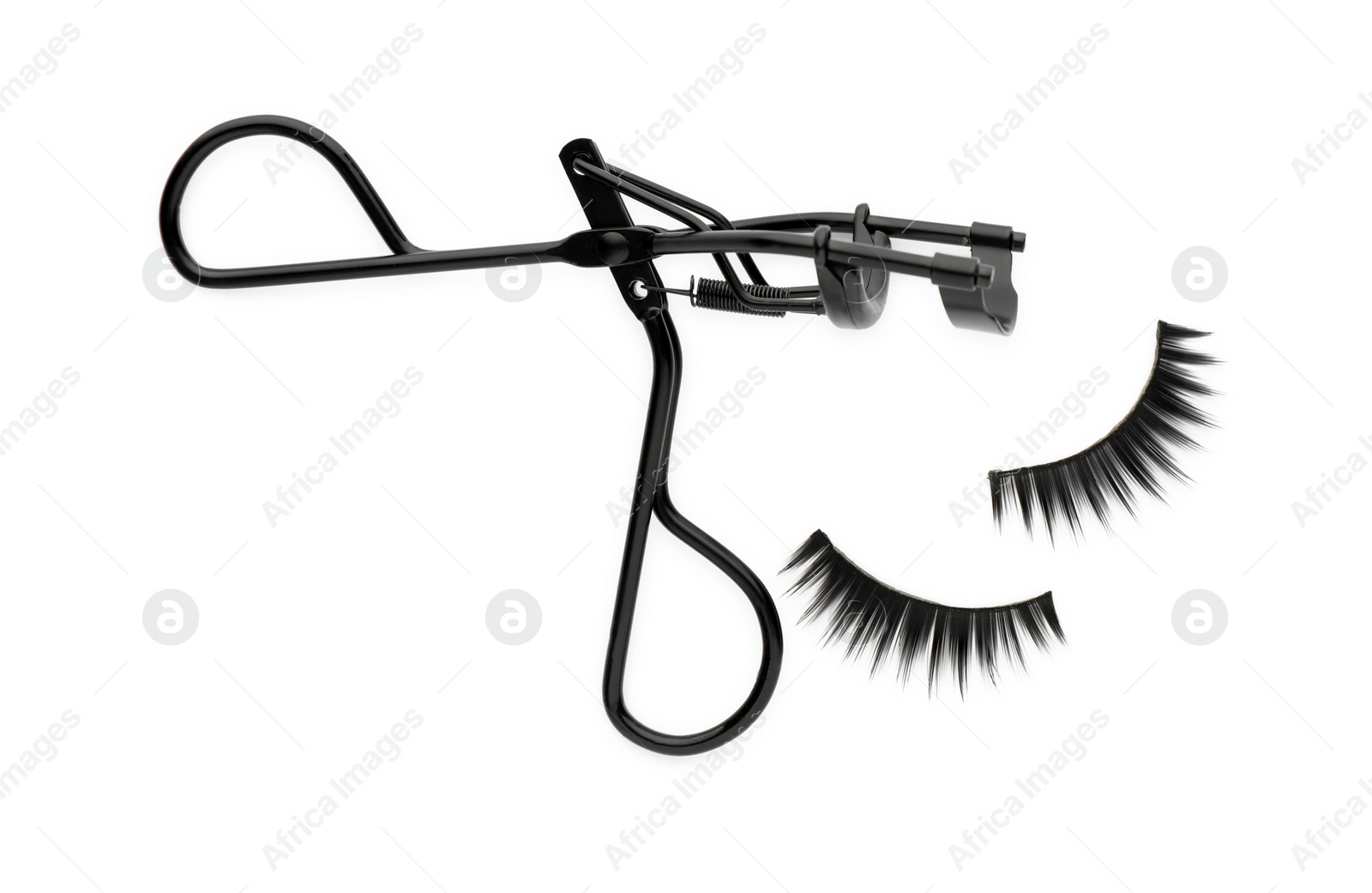 Photo of False eyelashes and curler on white background, top view