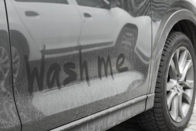 Phrase Wash Me written on dirty car, closeup