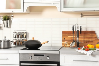 Set of clean cookware, utensils and products on table in modern kitchen