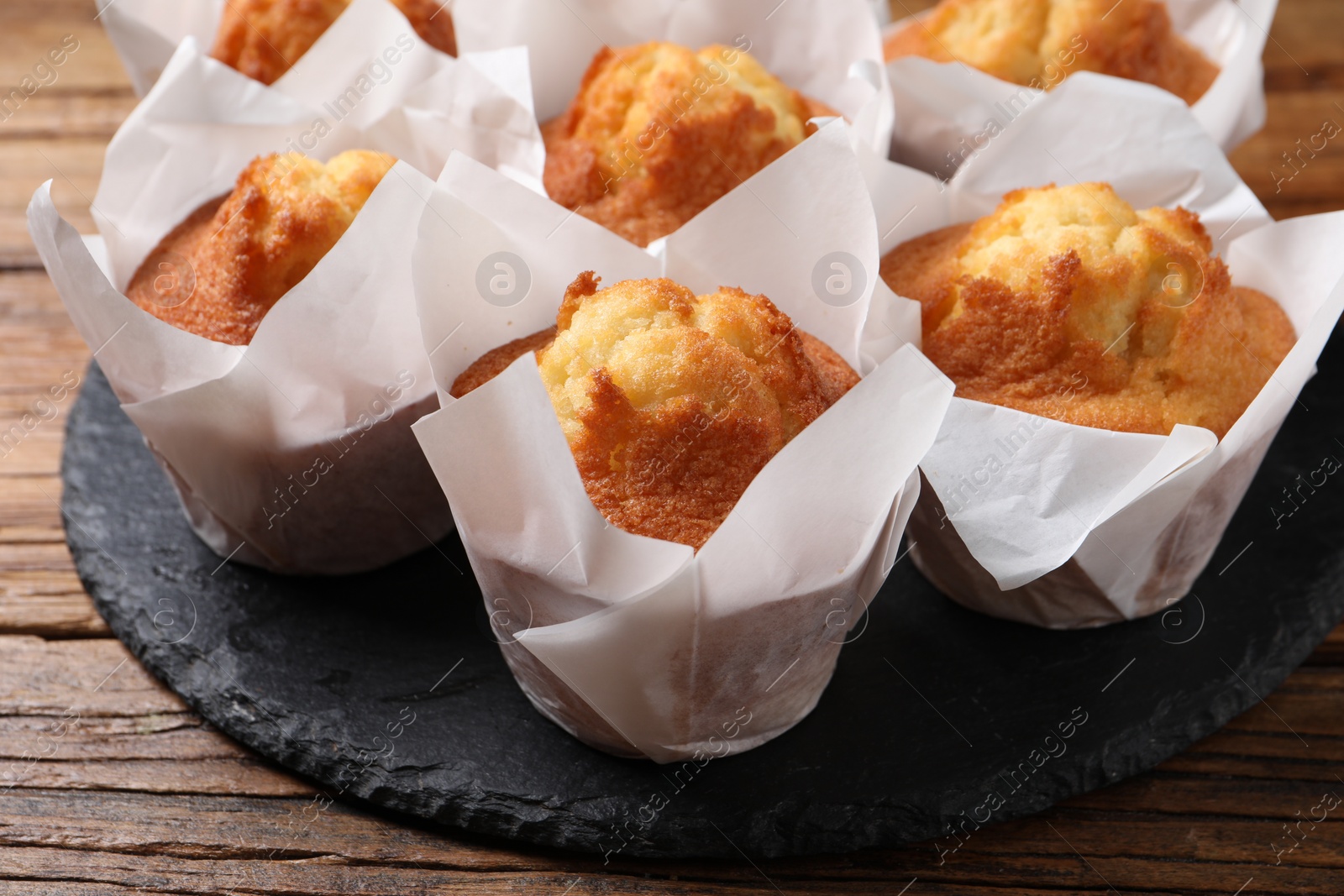 Photo of Delicious sweet muffins on wooden table, closeup