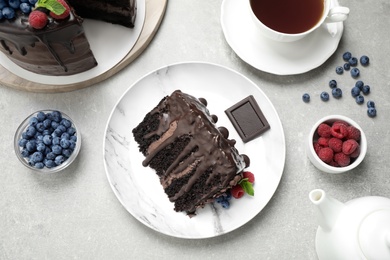 Photo of Delicious chocolate cake with fresh berries served on white table, flat lay