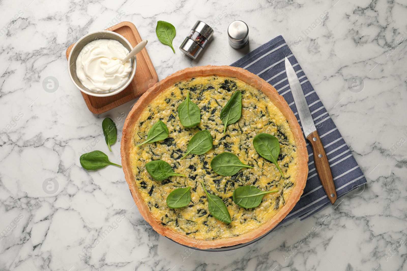 Photo of Delicious homemade spinach served on white marble table, flat lay