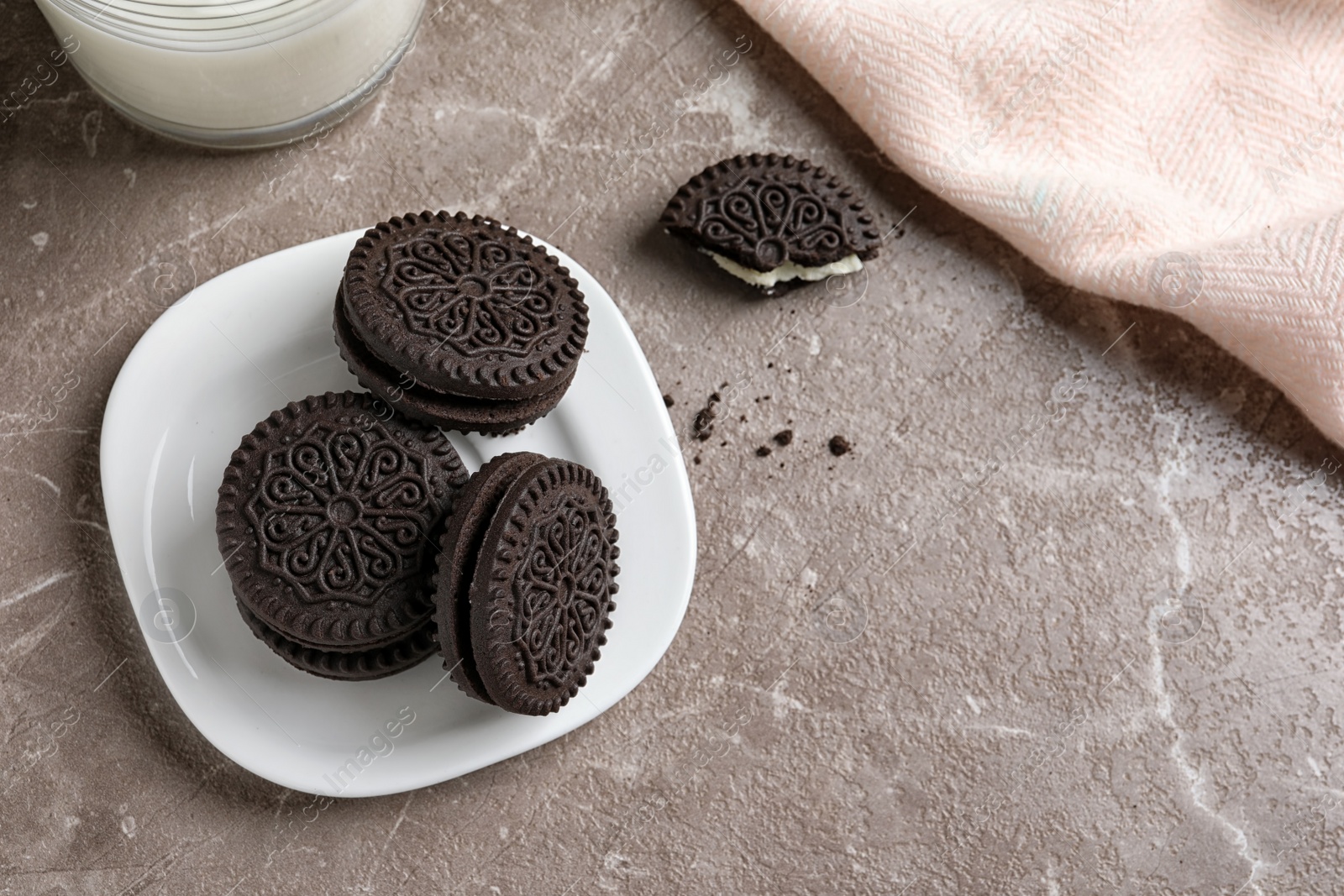 Photo of Plate with chocolate and cream cookies on table, top view. Space for text