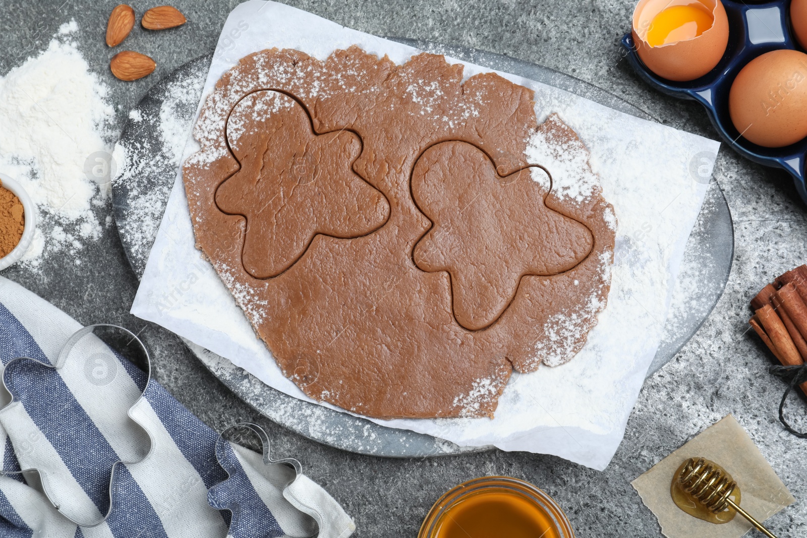 Photo of Flat lay composition with homemade gingerbread man cookies on grey table