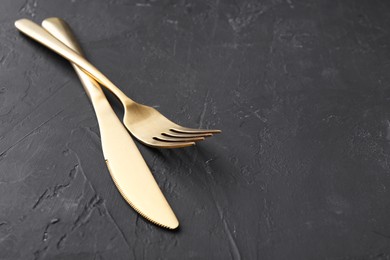 Photo of Beautiful cutlery set on black table. Space for text