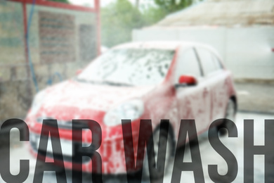 Text Car Wash and automobile covered with foam on background