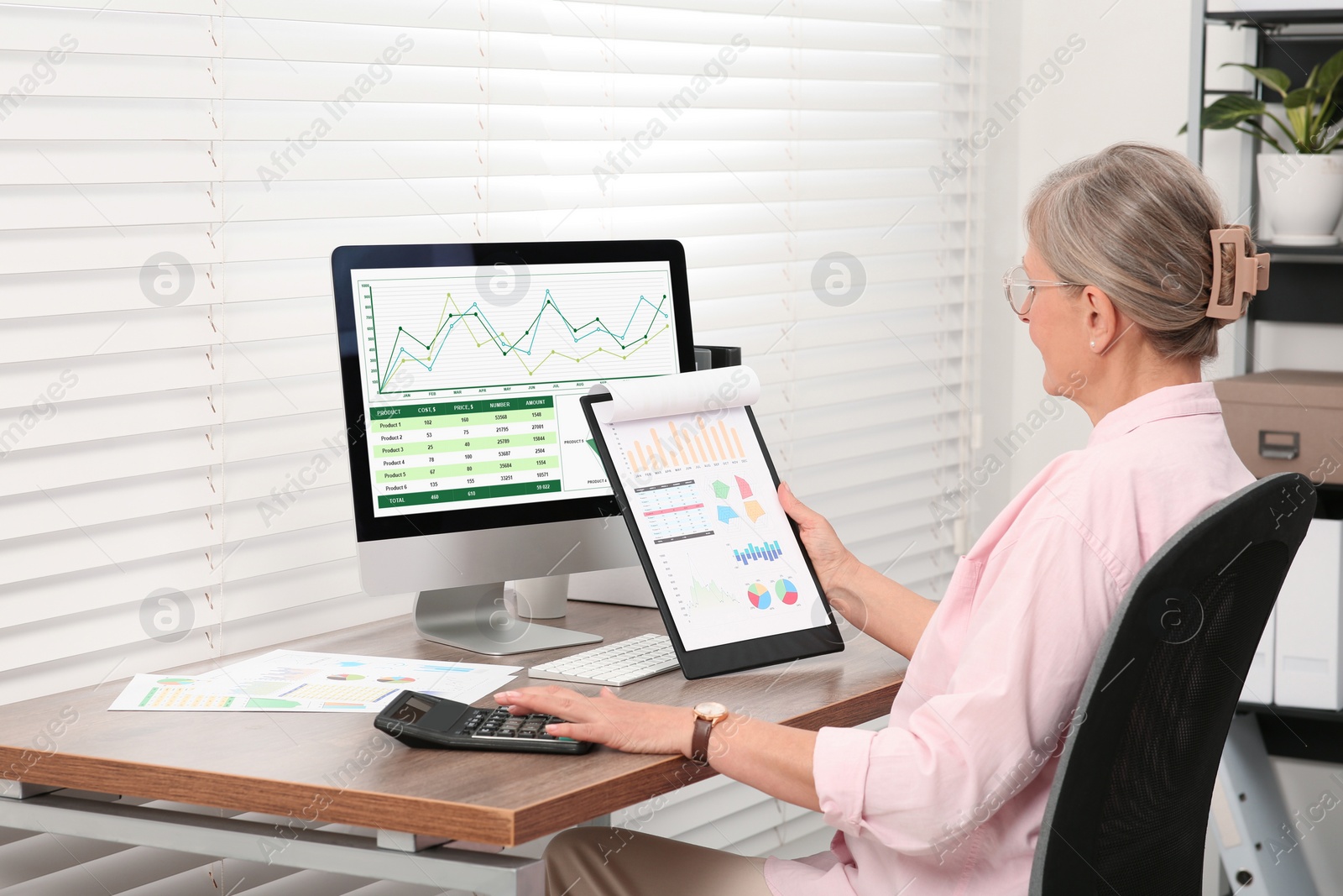 Photo of Senior accountant working at wooden desk in office