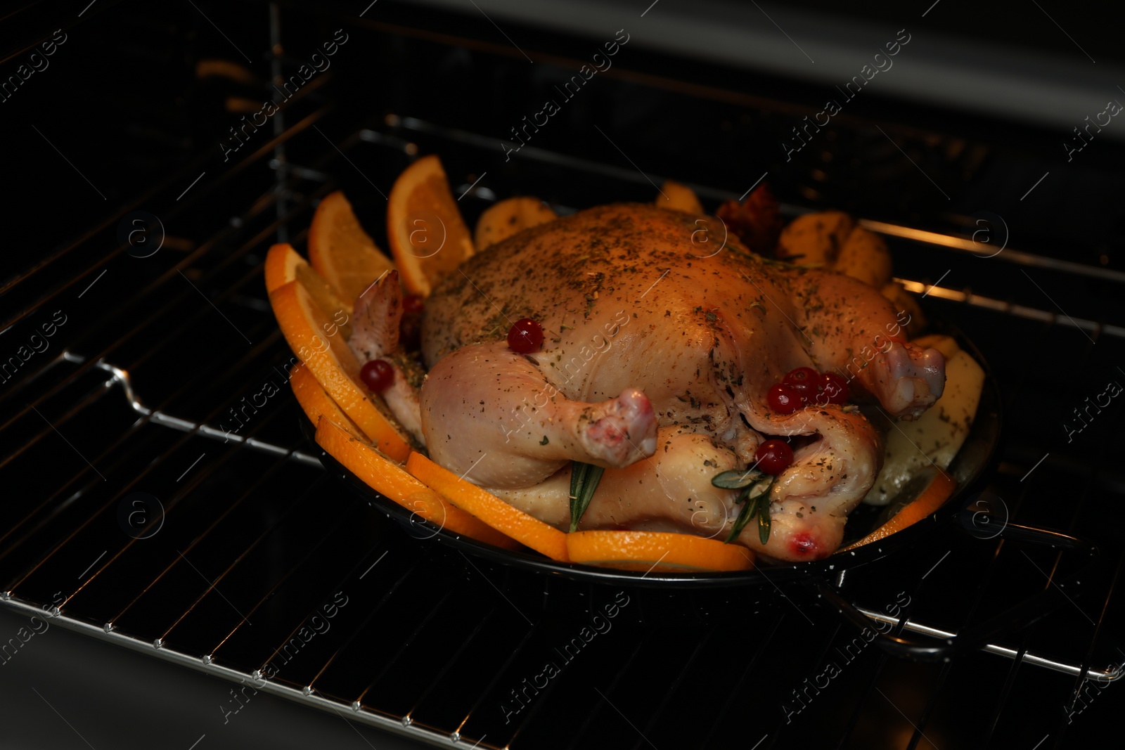 Photo of Chicken with orange slices baking in oven