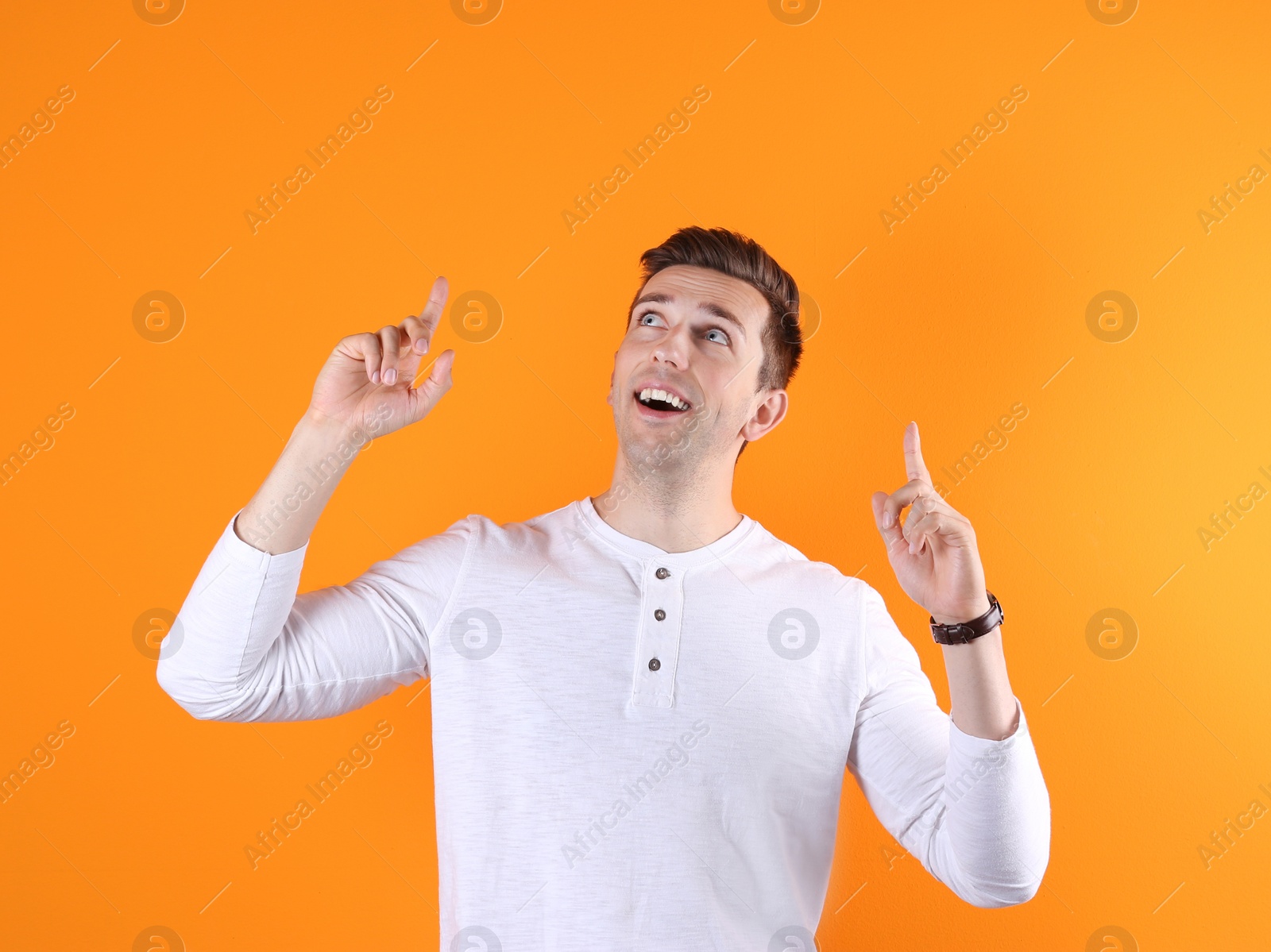 Photo of Handsome emotional young man on color background