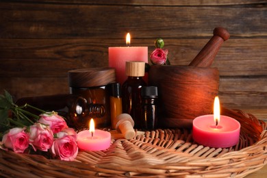 Photo of Beautiful composition with cosmetic products and pink roses in wicker tray. Aromatherapy treatment
