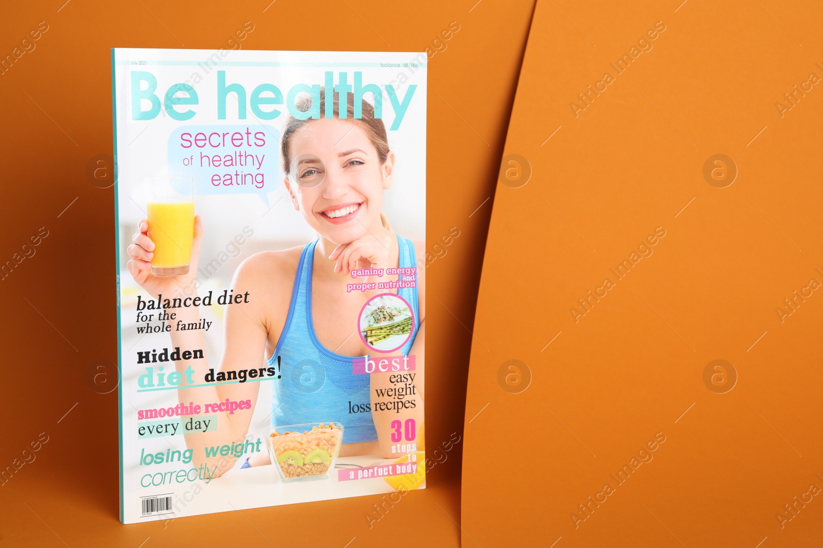 Photo of Modern printed healthy food magazine on orange background, space for text