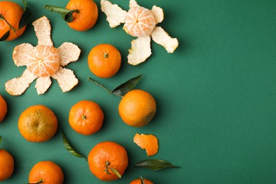 Photo of Many fresh ripe tangerines and leaves on green table, flat lay. Space for text