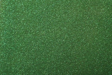 Photo of Beautiful shiny green glitter as background, closeup