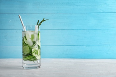 Photo of Natural lemonade with cucumber in glass on wooden table