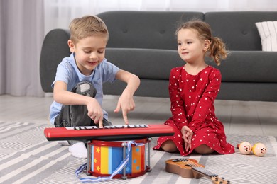 Little children playing toy musical instruments at home