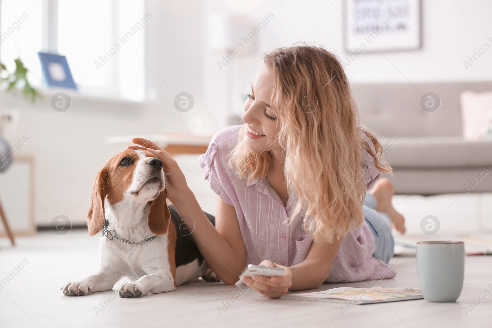 Photo of Young woman with her dog at home