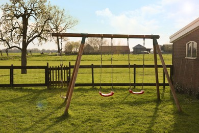 Photo of Outdoor swings near building on spring day