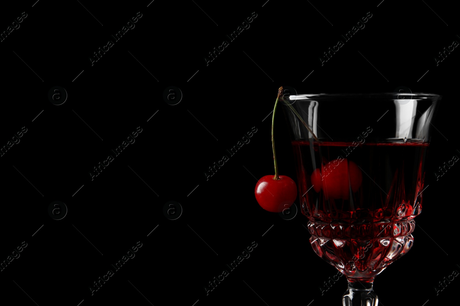 Photo of Delicious cherry wine with ripe juicy berries on black background, closeup. Space for text