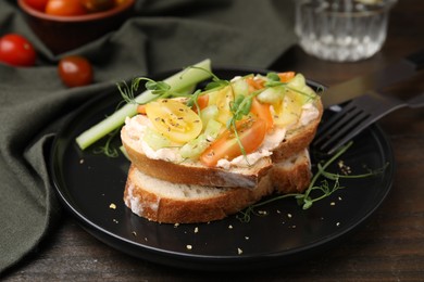 Tasty vegan sandwich with tomatoes, celery and microgreens on wooden table