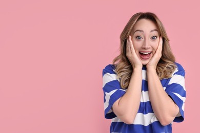 Portrait of happy surprised woman on pink background. Space for text