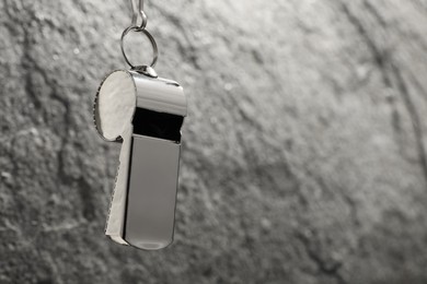 Photo of Referee equipment. Metal whistle on grey textured background, closeup and space for text