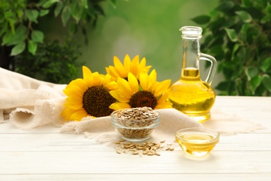 Photo of Composition with sunflower oil on white wooden table against blurred background