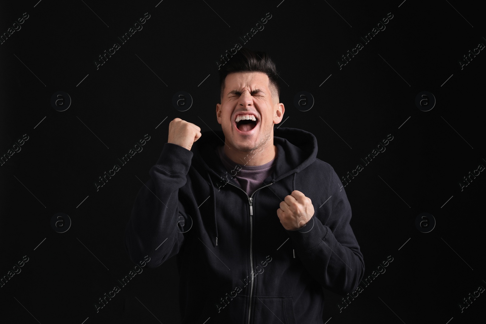 Photo of Portrait of emotional man on black background. Personality concept