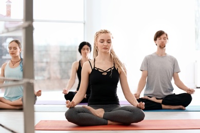 Photo of Group of people practicing yoga indoors