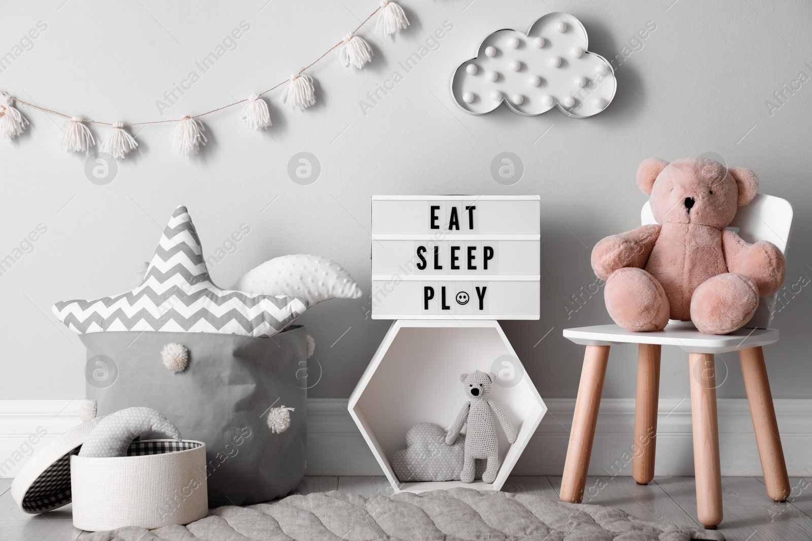 Photo of Light box with words Eat Sleep Play and cute toys in baby room. Interior design