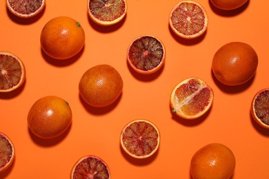 Photo of Many ripe sicilian oranges on orange background, flat lay