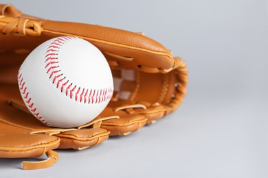 Catcher's mitt and baseball ball on white background, space for text. Sports game