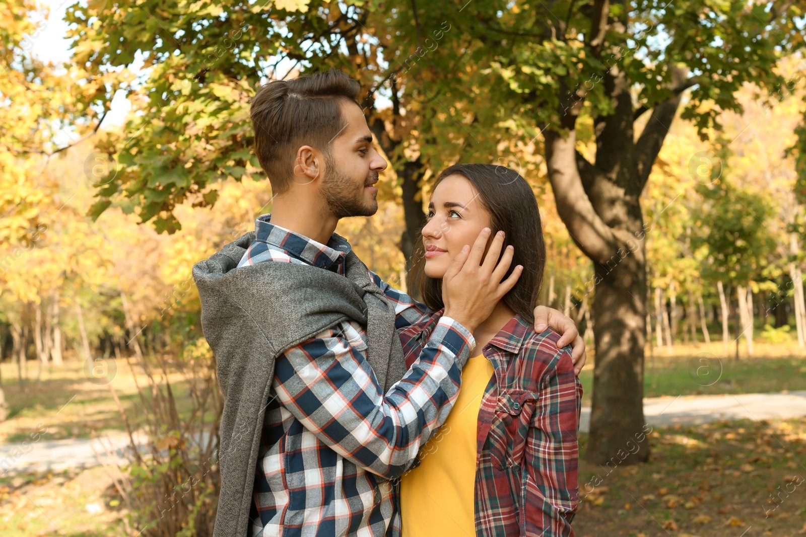 Photo of Young lovely couple spending time together in park. Autumn walk