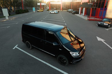 Photo of Black van on parking lot at sunset outdoors
