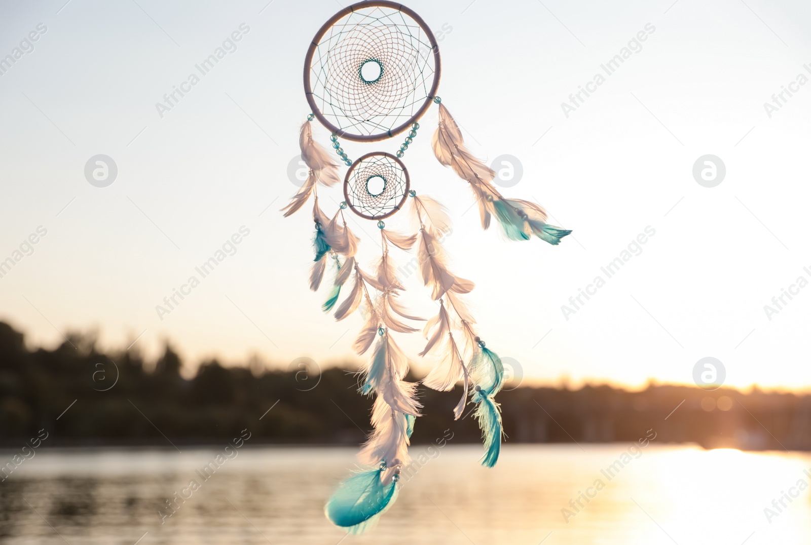 Photo of Beautiful handmade dream catcher near river on sunny day