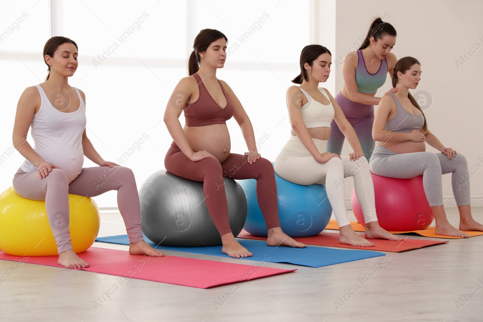 Photo of Trainer working with group of pregnant women in gym. Preparation for child birth