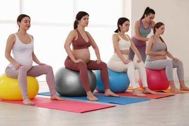 Trainer working with group of pregnant women in gym. Preparation for child birth