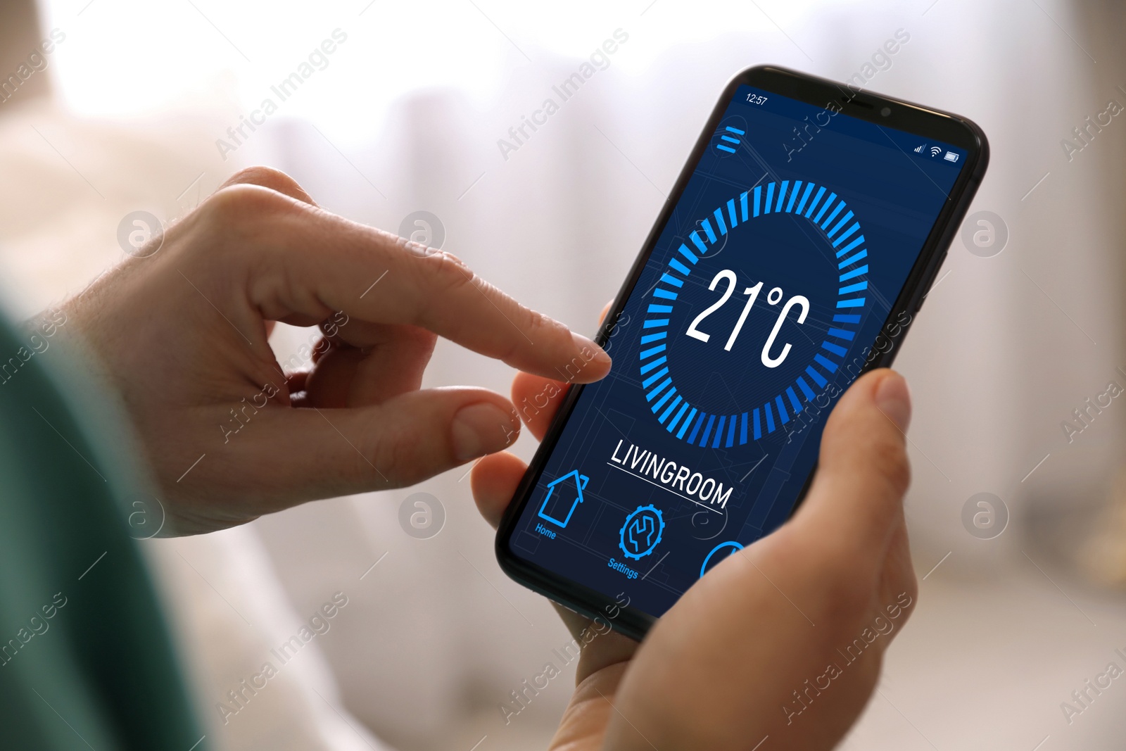 Image of Man using smartphone to control heating system in house, closeup