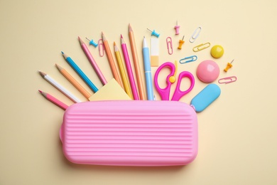 Photo of Case with different stationery on yellow background, flat lay