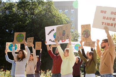 Photo of Group of people with posters protesting against climate change outdoors