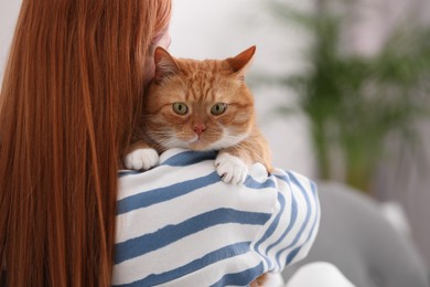 Photo of Woman with her cute cat at home, back view