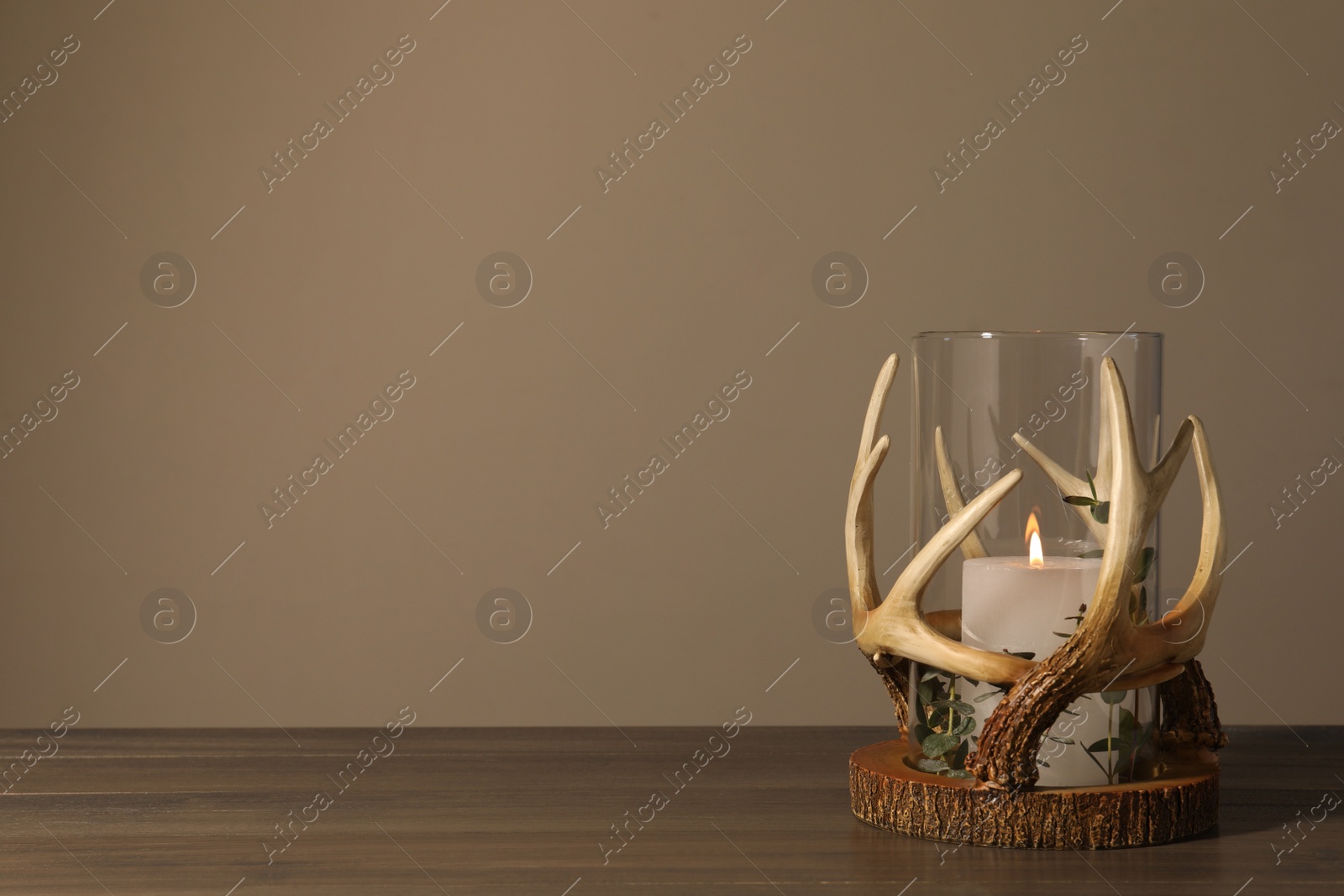Photo of Burning candles in beautiful holder on wooden table, space for text