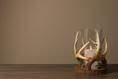 Burning candles in beautiful holder on wooden table, space for text